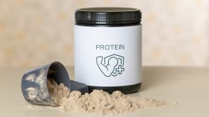 Chocolate protein supplement jar and scoop, muscle recovery and fitness. Protein is part of my daily training routine → linktr.ee/alexsaks.inspiration